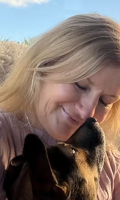 Kirsty smiling with her eyes closed as Harry nuzzles up to her face outdoors